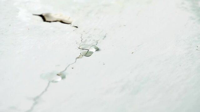 Water drips from ceiling. Faulty water supply in high-rise building. Cracked plaster on the ceiling.