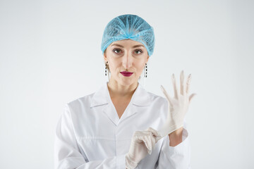 Female doctor puts on medical rubber gloves