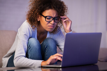 African-american student girl with bad eyesight using laptop