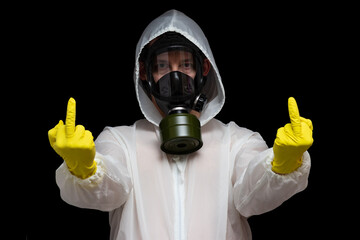 Outraged by toxic pollution, a man in a gas mask and a chemical protection suit shows a gesture...