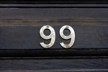 House number 99 on a black wooden front door