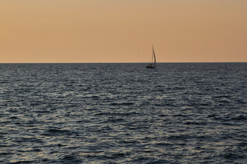 Sailing boat with a beautiful sunset at the sea