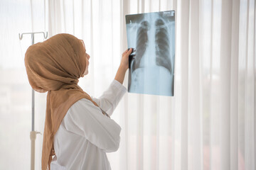 Muslim woman medical doctor looking at x-rays result in a hospital
