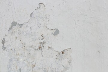 White painted and plaster of wall is peeling.