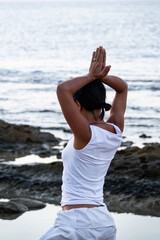 Fototapeta na wymiar woman in yoga pose on the beach with white clothes