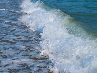 Perspective view of powerful sea wave with surf and foam. High shutter speed fixation, low angle, horizontal image