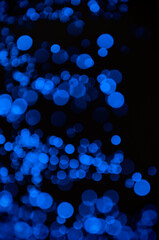 Abstract pattern of blue bokeh garland lights on a dark background
