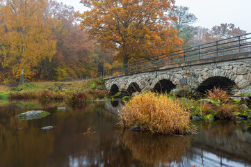 Fototapeta na wymiar Old stone bridge on autumn colors