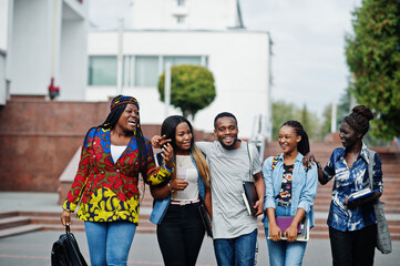 Fototapeta premium Group of five african college students spending time together on campus at university yard. Black afro friends studying. Education theme.