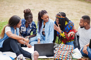 Group of five african college students spending time together on campus at university yard. Black...