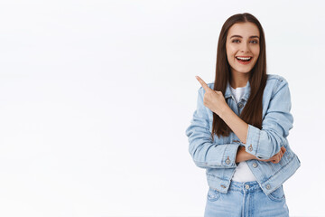 Enthusiastic young attractive caucasian woman laughing over awesome advertisement, pointing upper...