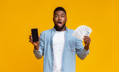 Afro guy holding cellphone with black screen and dollar cash