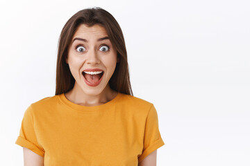 Thrilled, happy and joyful good-looking woman yelling from happiness and excitement, receive...