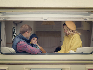 Mom, dad and son in a camper van, they like to travel and enjoy their family holidays. - 299938221