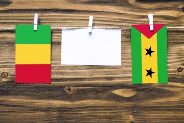 Hanging flags of Mali and Sao Tome And Principe attached to rope with clothes pins with copy space...