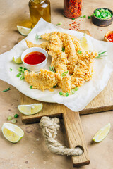 Breaded chicken strips with tomato sauces on a plate. Fast food on beige rustic background. Selective focus