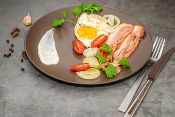 Fried hot omelette with tomatoes cherry and bacon on the dark background.