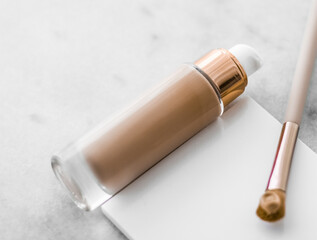 Makeup foundation bottle and contouring brush on marble, make-up concealer bb cream as cosmetics...