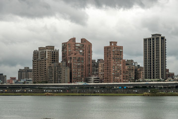 Fototapeta na wymiar Taipei grey weather view from Dadaocheng Dock towards Sanchong district with buildings in a modern as well as functional architectural style