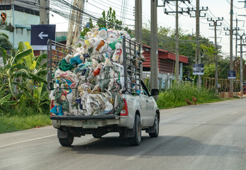 A fully loaded pickup carries a pile of old used empty bags, Bangkok, Thailand.