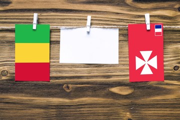 Hanging flags of Mali and Wallis And Futuna attached to rope with clothes pins with copy space on...