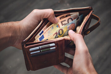 A leather wallet with Euro banknotes inside - obrazy, fototapety, plakaty