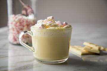 Heiße, weiße Trinkschokolade mit Sahne, Schokoladen Tafel und Marshmellows auf Marmor hell Hintergrund 