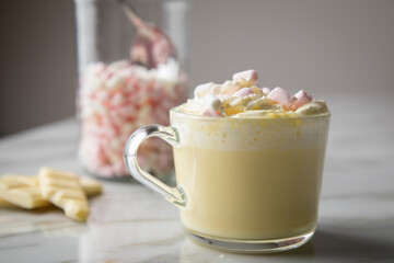 Heiße, weiße Trinkschokolade mit Sahne, Schokoladen Tafel und Marshmellows auf Marmor hell Hintergrund 