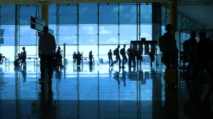 International airport with business people pulling trolley bags arriving and departing terminal tourists travelling and walking in lobby with big windows and blue sky 4k footage - Powered by Adobe