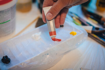 Tube with acrylic paint squeezed out on a table