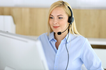 Call center. Blonde business woman sitting in headset at customer service office. Concept of telesales business or home office occupation