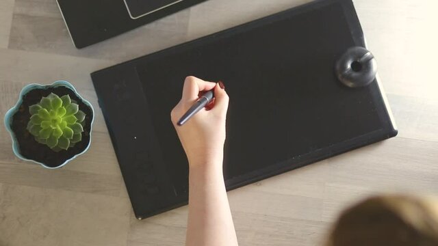 Designer working with graphics tablet, hands of a man working with drawing tablet for a computer, Soft focus shot(HD, high definition 1080p)  view from above.