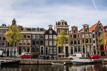 Amsterdam canal with typical dutch houses. Netherlands autumn cityscape. Boats.