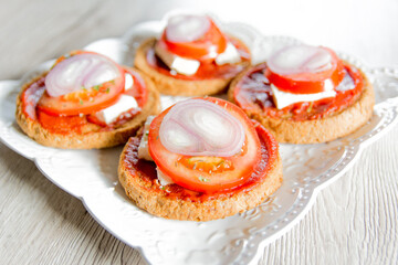 Bruschetta with tomato, onions and cheese on wooden table
