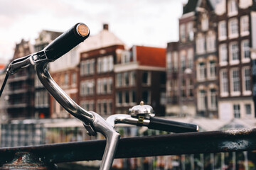 Close-up of bicycle handlebar. Amsterdam architecture.