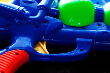 trigger for a blue plastic water gun lying on dark background