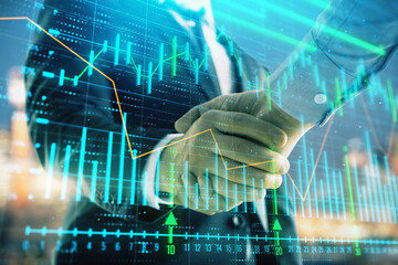 Double exposure of financial chart on cityscape background with two businessmen handshake. Concept of financial analysis and investment opportunities