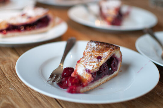 Close-up of tasty cherry pie on white plate, placed on wooden table