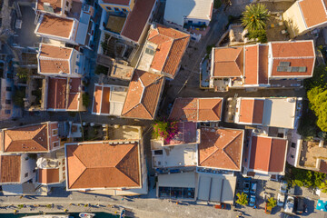 traditional multicolored historic Greek houses with beautiful roofs of the island city top view...