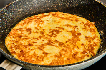 Cooking omellette on frying pan