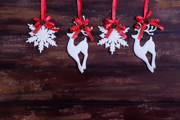 Snowflakes on a red ribbon hang a garland on a wooden background