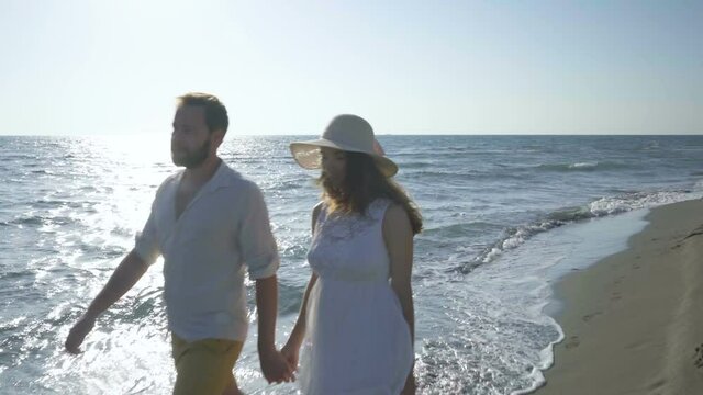 couple walking along the beach near the water