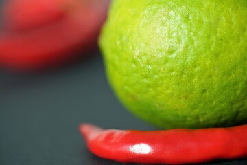 red pepper and green lime on a black background