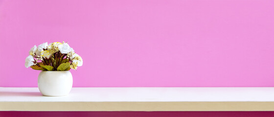 Pink wall background with flowers on shelf white wood.  copy space and banner for text. Still life...