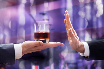 Hand Rejecting Glass Of Whiskey Offered By Person