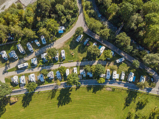 Aerial view of campground in rural area in Europe with many caravans. Concept of adventure and outdoor tourism in Europe.