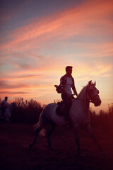  man riding  horses in the sunset.- freedom and hapiness