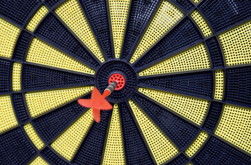 Red arrow hitting target on dart board against blurred green background . Goals concept    