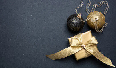 Xmas present and bauble shiny gold color against grey black background