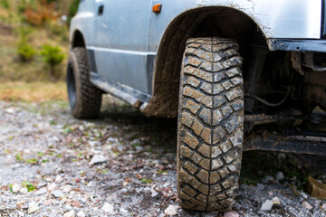 Fototapeta na wymiar Used cracked off road tire on off road vehicle , forest road close up shot with copy space.